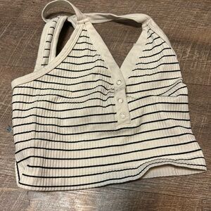 This tang top is white with black strips and is a size small in women’s